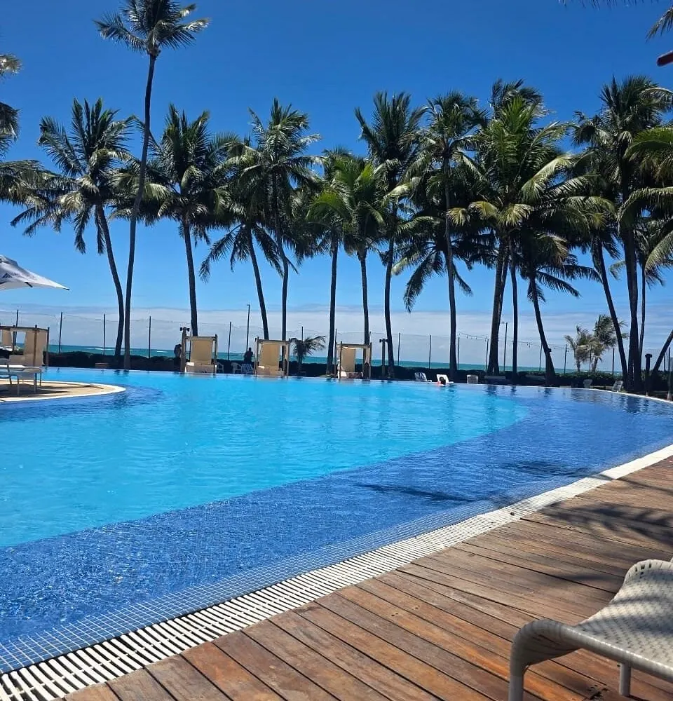 Piscina com o mar ao fundo no Jatiúca Hotel & Resort